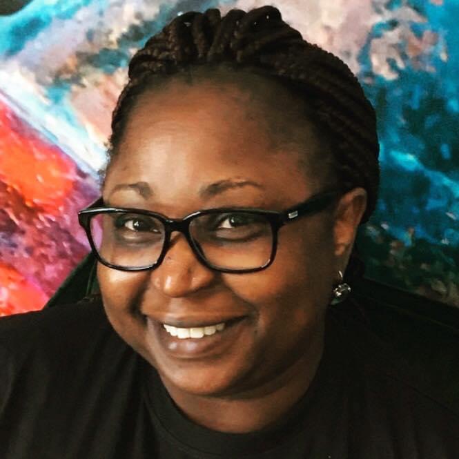 Yejide Kilankko - black woman with glasses and braids in front of a colourful background